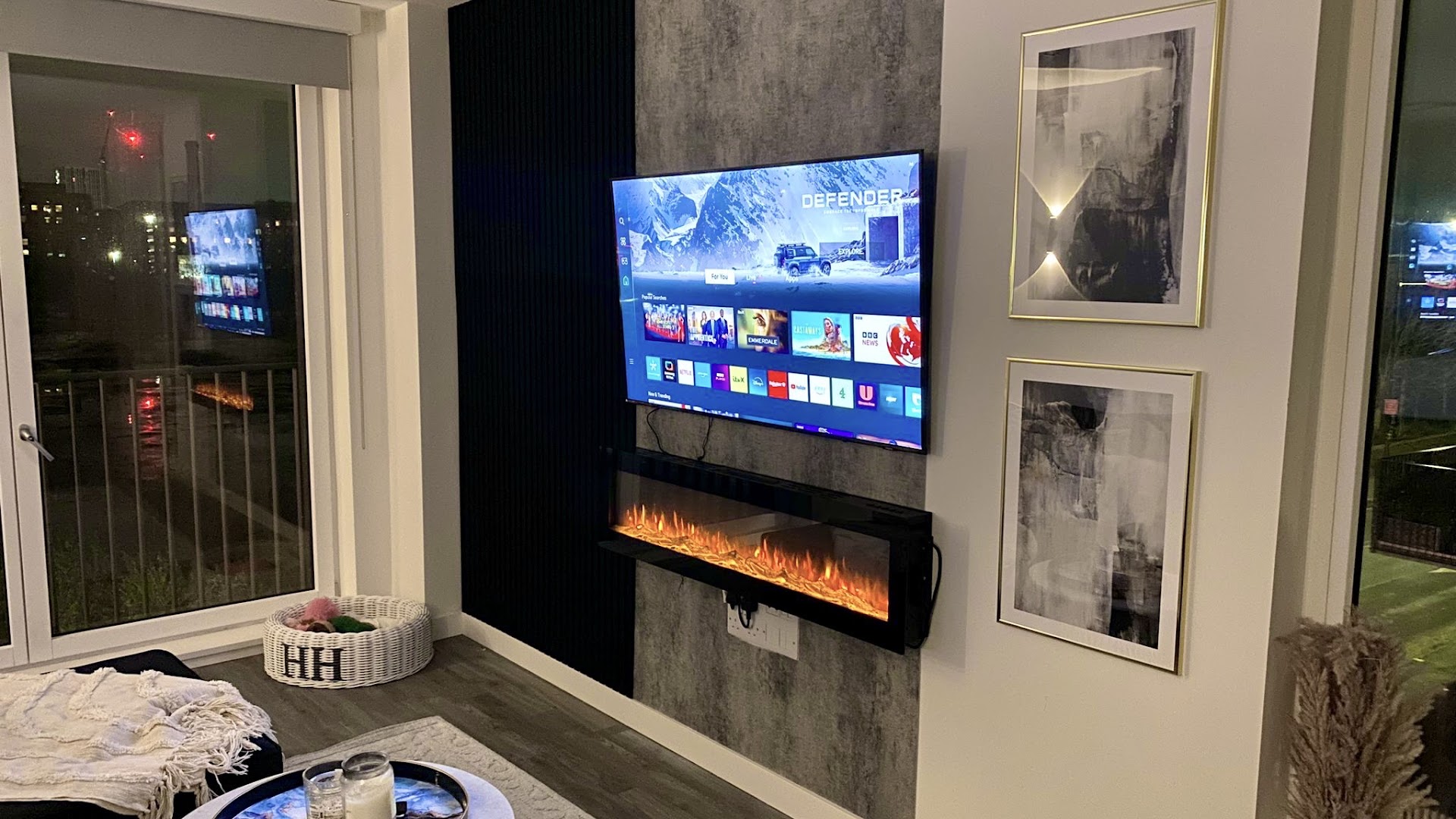 Mounted 65-inch TV on a built media wall with electric fire and framed art